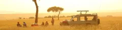 Banner Best of East Africa Group Tour safari guests enjoying bush sundowners