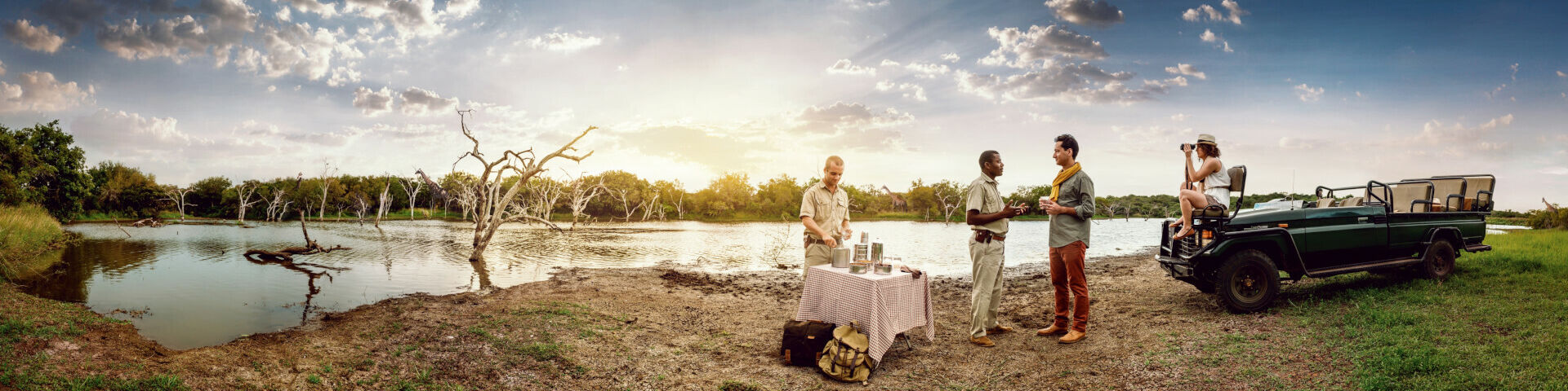French couple enjoying refreshments at the side of a lake in Phinda